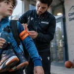 stages multi activités grenoble : enfant avec gourde et brassard, moniteur au complexe sportif